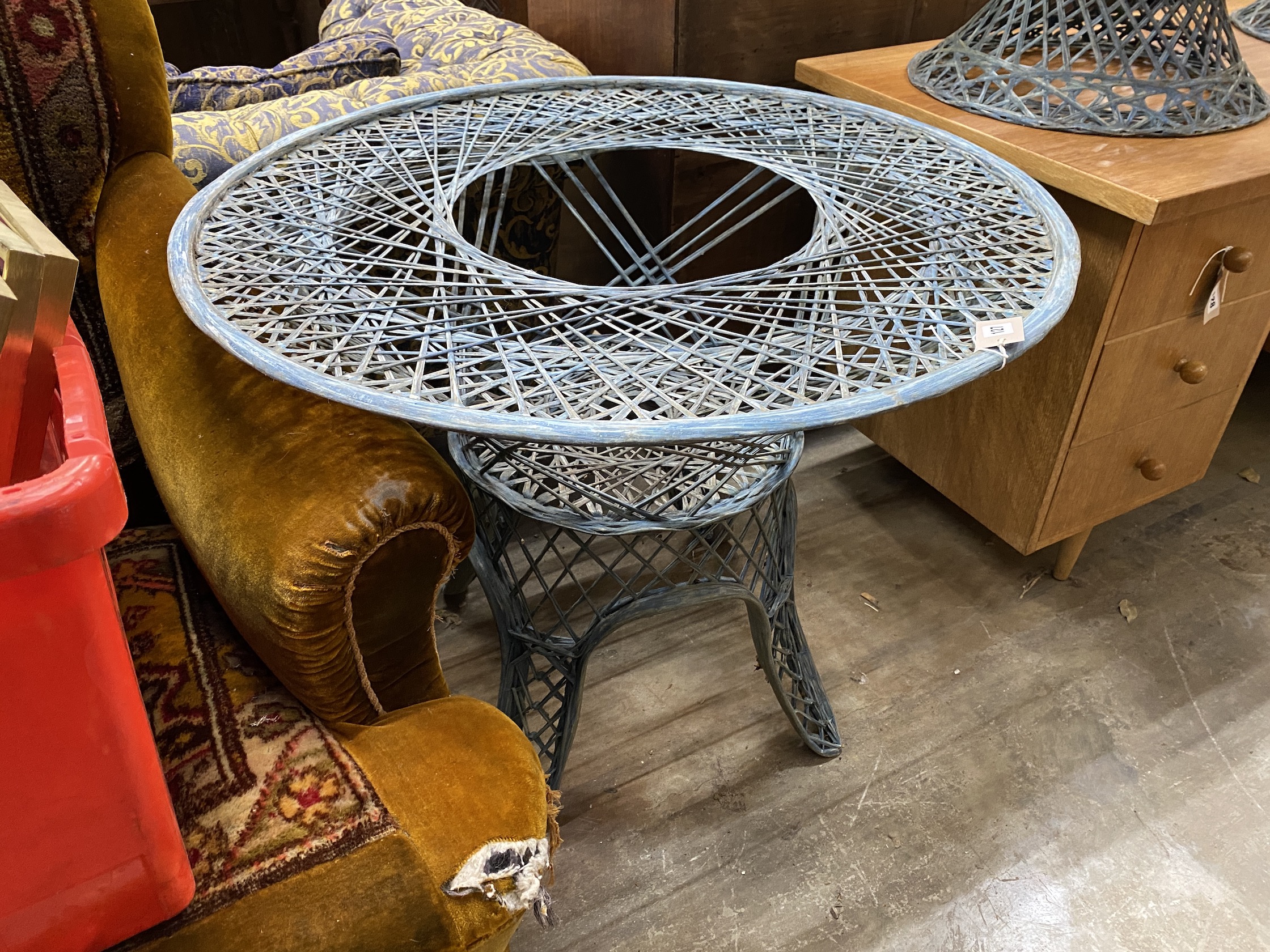 A painted wrought iron circular garden table, by Russell Woodard, diameter 88cm, height 70cm (lacking glass top), together with two matching chairs